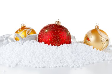 Karda parlak yüzeyi kırmızı ve altın Noel topları. 