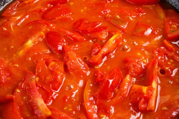 Bunch of fresh red tomatoes sliced stewed in a pan — Stock Photo, Image