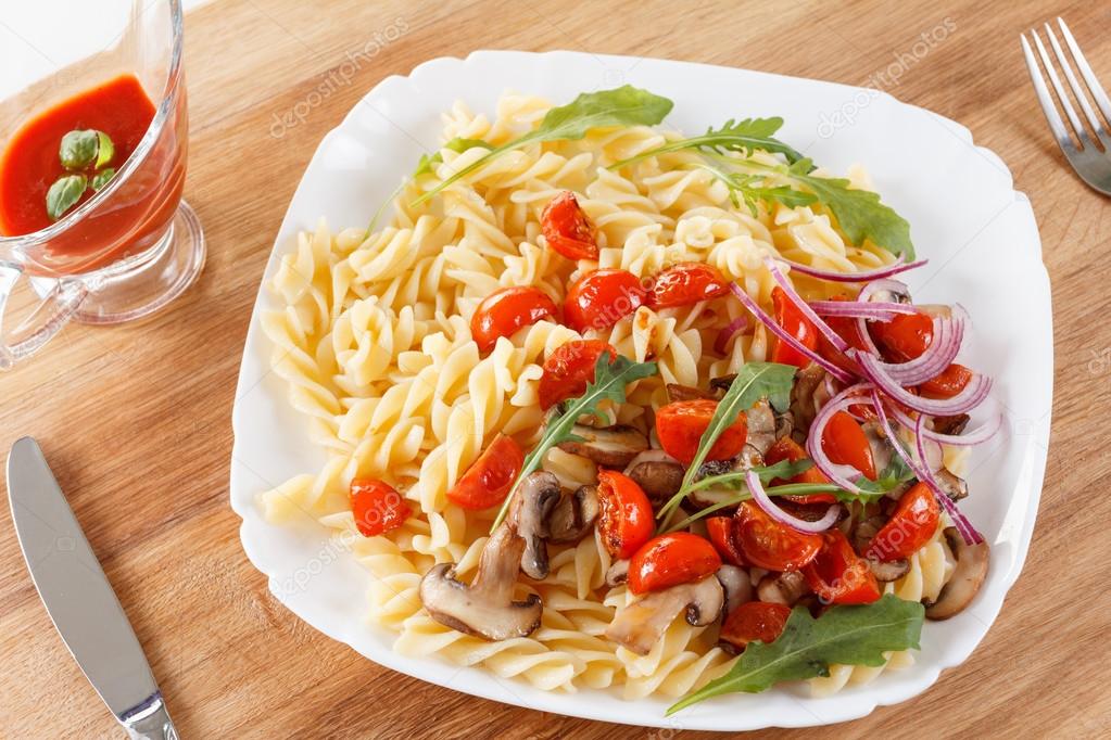 Pasta with mushrooms, cherry tomatoes and tomato sauce, italian food. Closeup