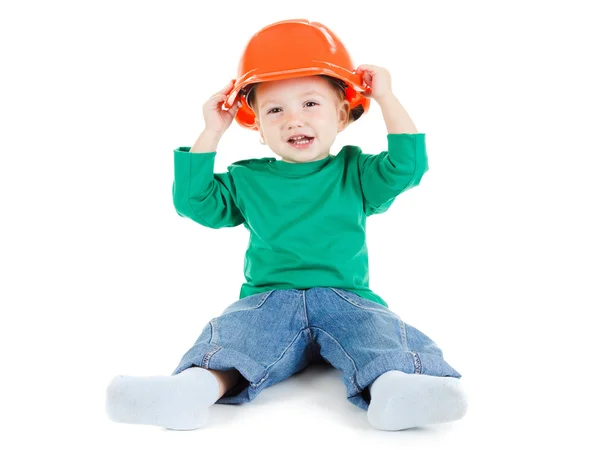 小さな子供は遊んで白地オレンジ建設保護ヘルメット. — ストック写真
