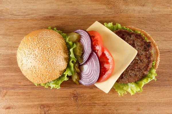 Hamburguesa tradicional americana con queso. Carne, bollo y verduras de cerca —  Fotos de Stock