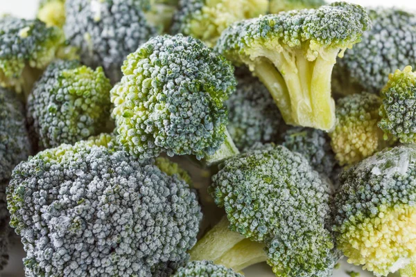 Bevroren broccoli met ijskristallen op witte achtergrond — Stockfoto