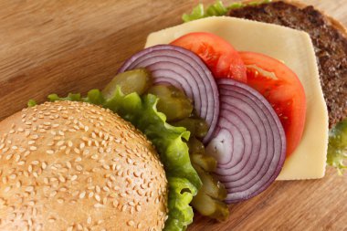 Geleneksel Amerikan çizburger. Et, topuz ve sebze kapat