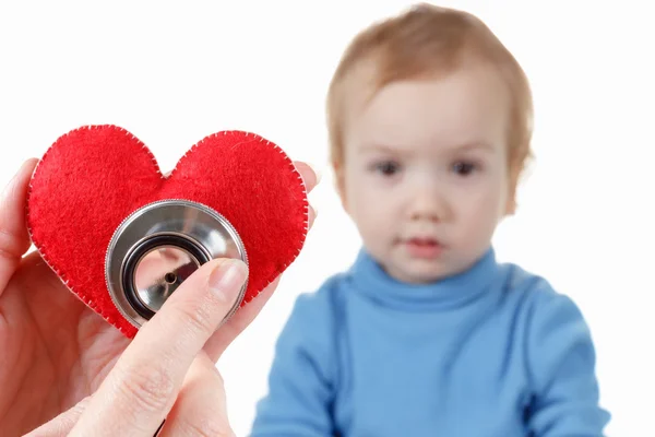 Dziecko i kardiolog, serce symbol w ręku, stetoskop. — Zdjęcie stockowe