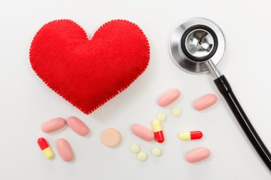 Kırmızı kalp ve beyaz arka planda steteskop.