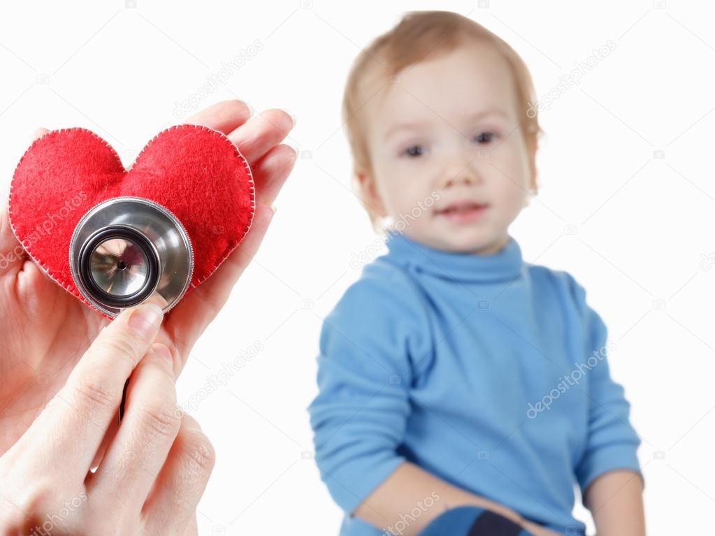 Child and cardiologist, heart symbol in hand, stethoscope.