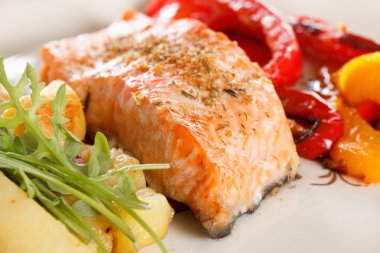 Sebze, baharatlar ve roka bir plaka üzerinde ızgara somon fileto