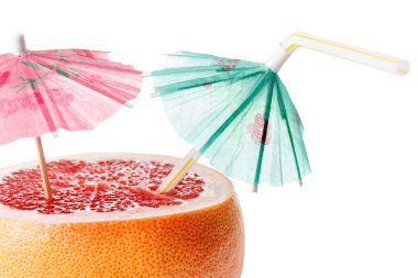 Cut grapefruit cocktail with umbrella, isolated on white  