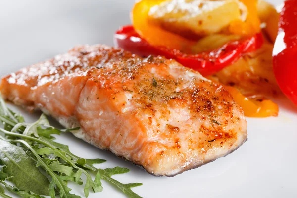 Filé de salmão grelhado com legumes, especiarias e rúcula em um prato — Fotografia de Stock