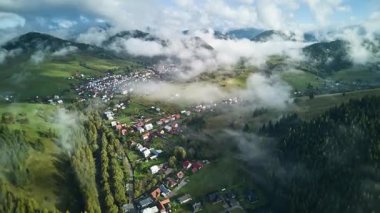 Dinamik hava hipervanesi tepeler ve ormanlarla çevrili küçük bir dağ köyünü gösteriyor. Alçak sabah sisi vadide sürükleniyor. Güneş ışığı yavaşça manzarayı aydınlatıyor ve canlı bir hava yaratıyor.