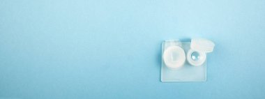 Miyop insanlar için konteynır kutusunda bir çift sert lens. Mavi arkaplan panosuna seçici odak.