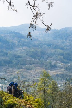 İki kadın dağlarda dinleniyordu (Yuan yang terasları, yunnan, Çin)