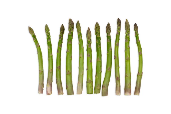 Grupo de espargos de vegetais verdes saudáveis organizados em uma fileira isolada em um fundo branco como um conceito de comida de dieta saudável e viver um ajuste natural vida bem nutrida. — Fotografia de Stock