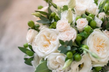 Gelin buketi. Gelinin buketi. Güzel bir buket beyaz, çiçekler ve yeşillik, uzun ipek kurdele ile süslenmiş gri dokuma arka planda yatıyor.