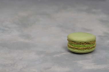 Koyu gri beton arka planda bir kule şeklinde çok renkli badem kurabiyeleri. Gri beton arka planda makaronlar. Pastalar üst üste. Metin için boşluk, kopyala boşluk.