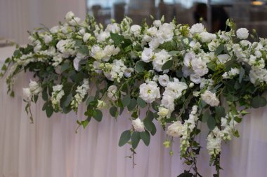 Güzel çiçeklerle dolu bir düğün resepsiyonunda ana masa. Düğün günü. Pembe çiçekli düğün kimlikleri.