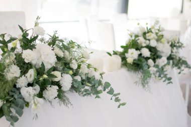 Güzel çiçeklerle dolu bir düğün resepsiyonunda ana masa. Düğün günü. Pembe çiçekli düğün kimlikleri.