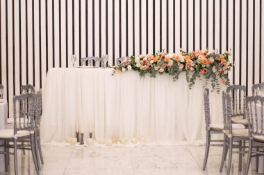 Güzel çiçeklerle dolu bir düğün resepsiyonunda ana masa. Düğün günü. Pembe çiçekli düğün kimlikleri.