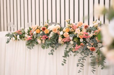 Güzel çiçeklerle dolu bir düğün resepsiyonunda ana masa. Düğün günü. Pembe çiçekli düğün kimlikleri.