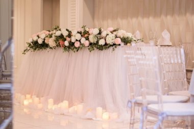 Düğün resepsiyonundaki ana masada güzel taze çiçekler var.