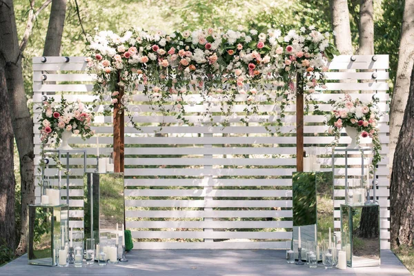 Cerimonia nuziale. Arco da sposa molto bello ed elegante, decorato con vari fiori freschi, in piedi nel giardino. — Foto Stock