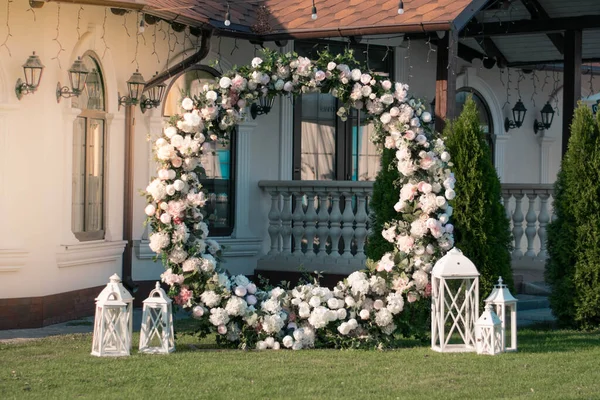 Cerimônia de casamento. Arco de casamento redondo muito bonito e elegante, decorado com várias flores frescas, de pé no jardim. — Fotografia de Stock