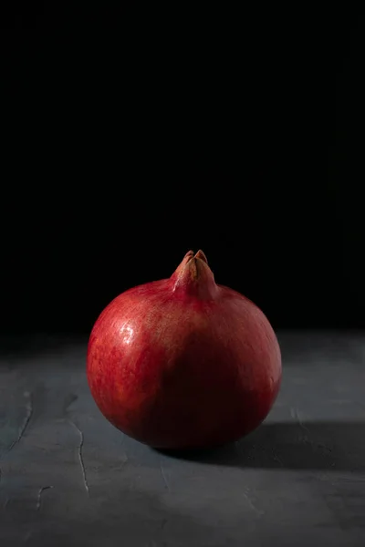 En röd enda granatäpple på svart bakgrund. Färska frukter. — Stockfoto