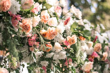 Düğün töreni. Çok güzel ve şık bir düğün kemeri, çeşitli taze çiçeklerle süslenmiş, bahçede duruyor. Düğün günü. Taze çiçek süslemeleri, şakayıklar..