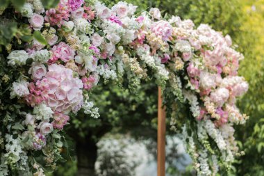 Düğün töreni. Çok güzel ve şık bir düğün kemeri, çeşitli taze çiçeklerle süslenmiş, bahçede duruyor. Düğün günü. Taze çiçek süslemeleri, şakayıklar..