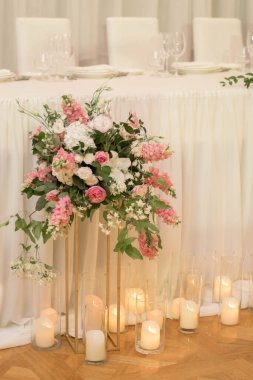 Güzel çiçeklerle dolu bir düğün resepsiyonunda ana masa. Düğün günü. Pembe çiçekli düğün kimlikleri.