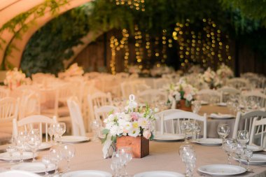 Güzel çiçeklerle dolu bir düğün resepsiyonunda ana masa. Şakayık düğün süslemeleri.