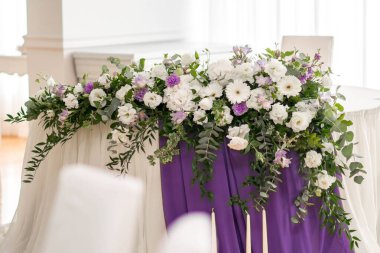 Güzel çiçeklerle dolu bir düğün resepsiyonunda ana masa. Düğün günü. Pembe çiçekli düğün kimlikleri.