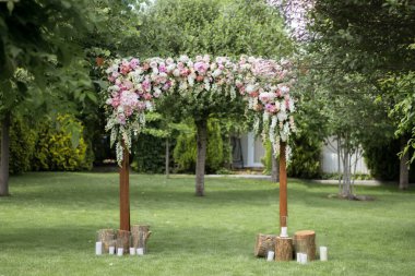 Düğün töreni. Çok güzel ve şık bir düğün kemeri, çeşitli taze çiçeklerle süslenmiş, bahçede duruyor. Düğün günü. Taze çiçek süslemeleri, şakayıklar..