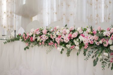 Güzel çiçeklerle dolu bir düğün resepsiyonunda ana masa. Düğün günü. Pembe çiçekli düğün kimlikleri.