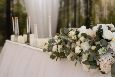 Güzel beyaz çiçeklerle dolu bir düğün resepsiyonunda ana masa.