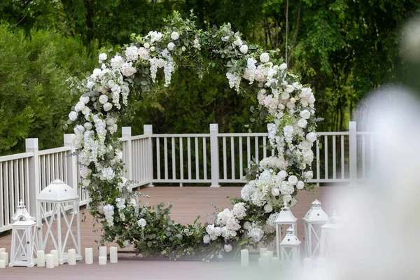 Ceremonia de boda. Arco de boda redondo muy hermoso y elegante, decorado con varias flores, de pie en la terraza. — Foto de Stock