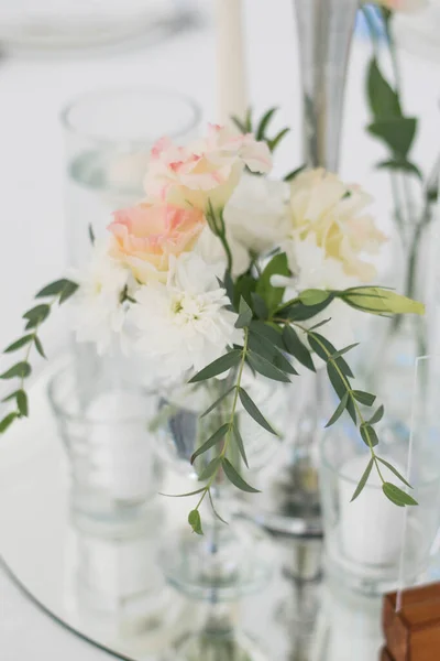 Zbliżenie weselnego stołu w recepcji. Świeże kwiaty i świece na talerzu lustra. Dekoracje ślubne. — Zdjęcie stockowe