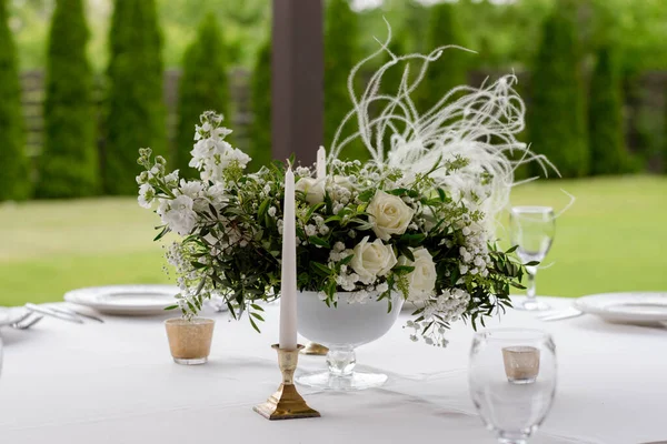花瓶内摆放有白花和绿花的桌子中心. — 图库照片