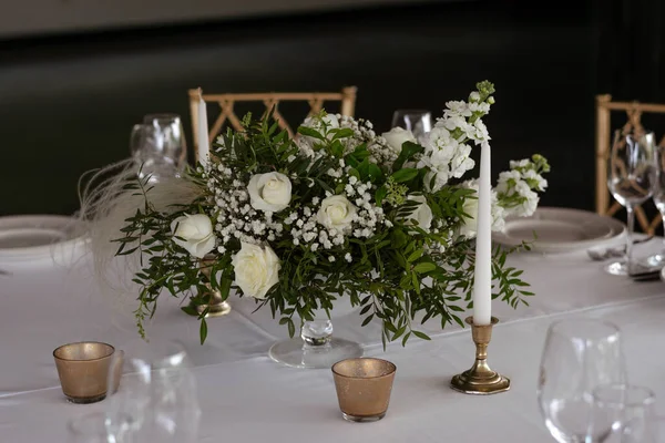 Bordsskiva med vita och gröna blomsterarrangemang i vas. — Stockfoto