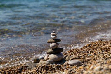 Deniz çakıl taşları, deniz suyunun arka planında kumsal manzaralı..