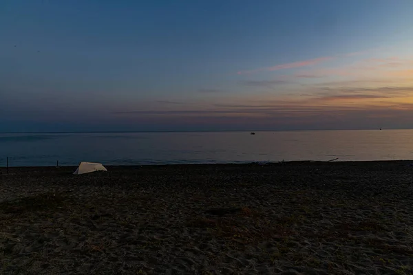 Zee Landschap Met Een Zonsondergang Een Eenzame Boot Het Strand — Stockfoto