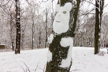 Parktaki kar ayısı kardan yapılmış bir ağaçta