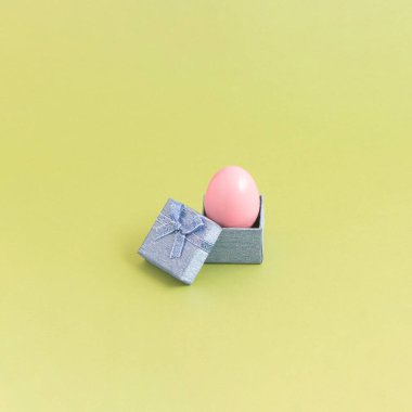 Sarı arka planda hediye kutusunda paskalya yumurtası. Konsept ortaya çıktı. 2021