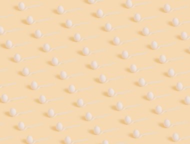 Beyaz kaşık ve paskalya yumurtalarından yapılmış yaratıcı bir model. Güzel pastel arka plan. Mini konsepti aç. 2021