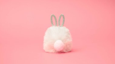 Pastel pembe arka planda pırlanta kulaklı tüylü paskalya tavşanı. Asgari modern kompozisyon.