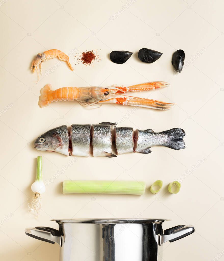 Fish soup fresh ingredients in free fall in the kitchen pot against beige natural background. Minimal infographic food concept. Flat layout.