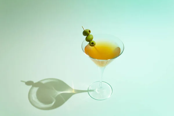 Martini Glass Filled Orange Drink Olives Stick Turquoise Sunny Background — Stock Fotó