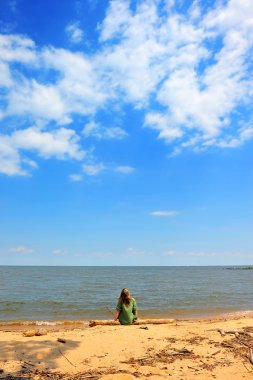Bir yaz gününde, bulutlar bir plajda ararken bir kız