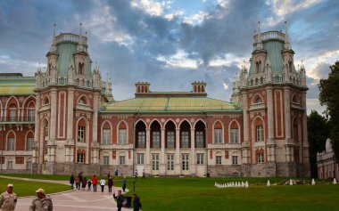 Muazzam bir saray kompleksinin panoramik görüntüsü zarif Gotik diriliş mimarisini gözler önüne seriyor. Ön cephe, ziyaretçilerin yemyeşil zeminde yürüdüğü simetrik kuleler, dekoratif duvarlar ve zarif kemerli galerilerle tanımlanır..