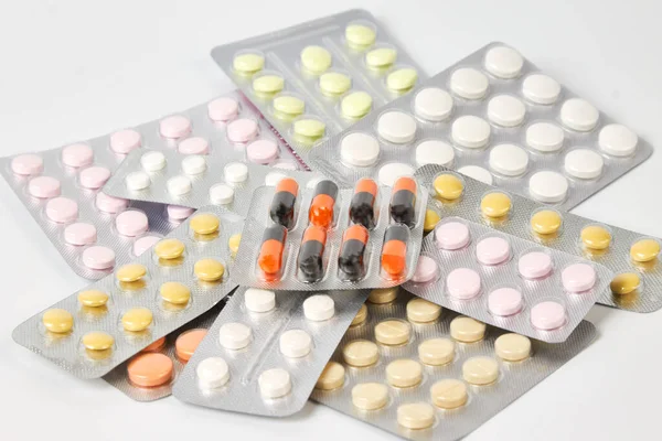 A bunch of pill packs on a gray background close-up